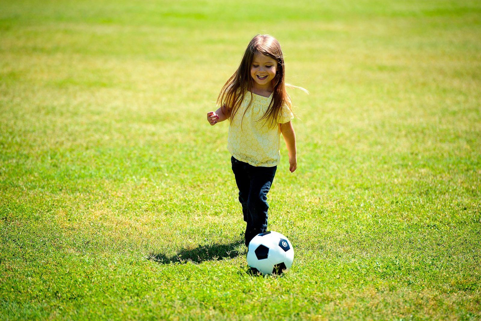 Child playing football on field
