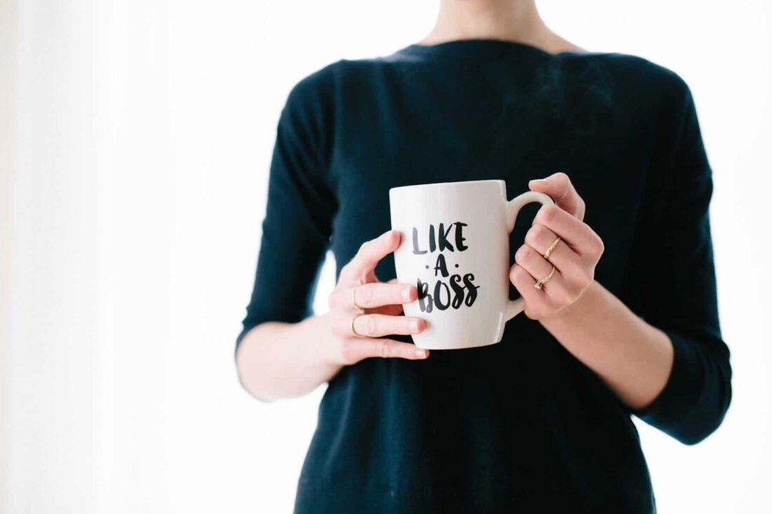Photo of a woman holding a mug that reads like a boss